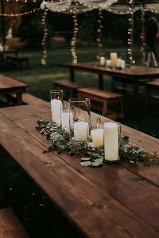 Hurricane vases and candles on wooden Farm Tables