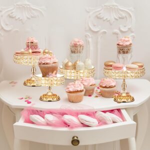 A set of gold cake stands of various sizes with crystal edge detailing, displayed elegantly on a dessert table.
