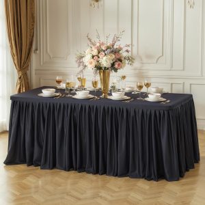 Black pleated ruffle table skirt displayed on an 8ft rectangular table with décor items on top, shown with multiple color options.